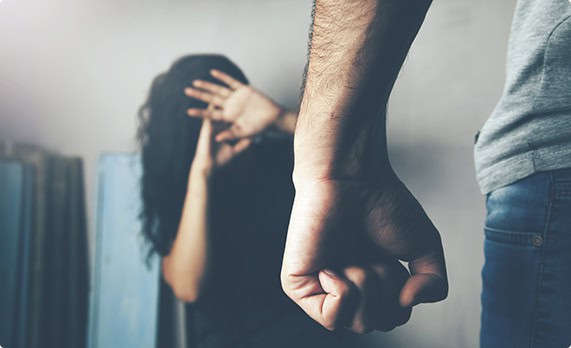 An angry man's hand points at a woman, covering her face with her hand, representing domestic violence - John Abel Law Office